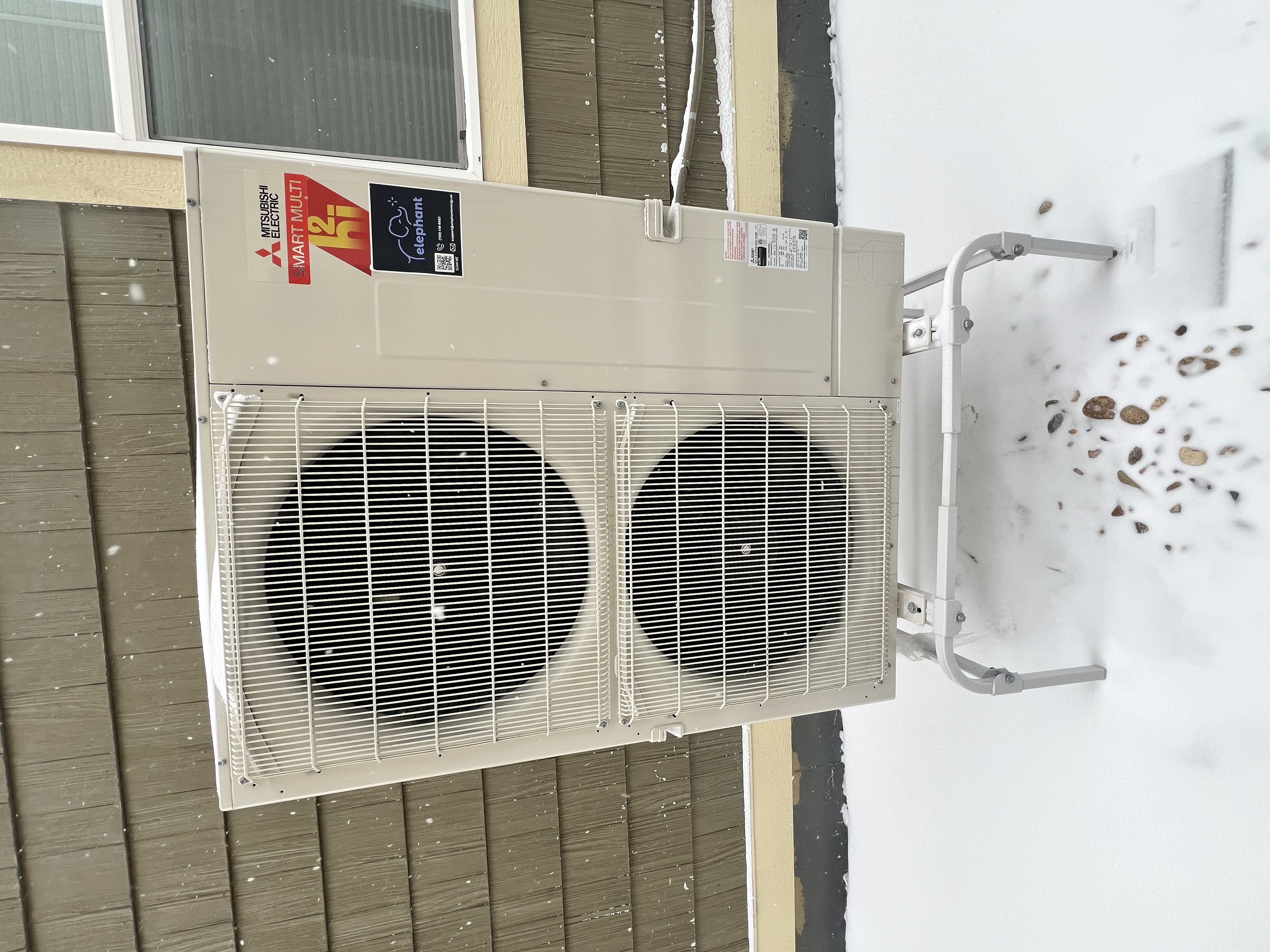 Mitsubishi Smart Multi h2i heat pump with Elephant Energy sticker, running in snow